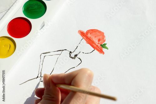 Художник рисует женщину кисточкой и красками на белой бумаге