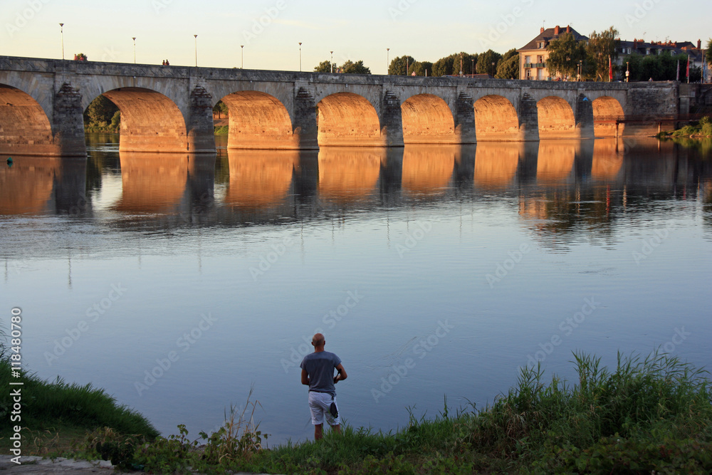 Fototapeta premium Pêche à la ligne au coucher du soleil au bord de la Loire à Saumur, France