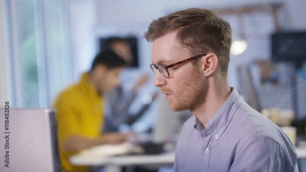 Portrait of smiling casual businessman working on laptop in office Portrait of smiling casual businessman working on laptop in office
