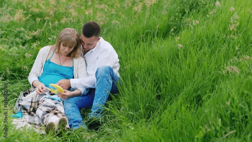 A pregnant woman with her husband considered toys for their unborn baby