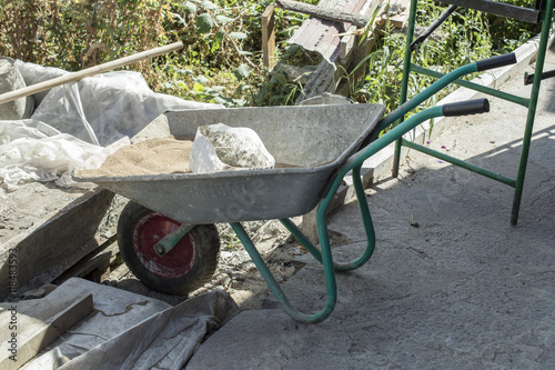 Construction tools and materials: wheelbarrow, cement and sand