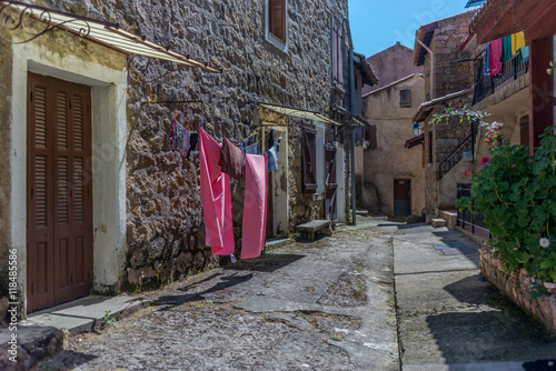 Fototapeta Naklejka Na Ścianę i Meble -  Typical street with drying hanging clothes in a small village in