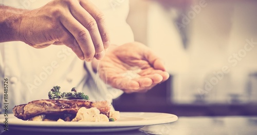 Closeup mid section of a chef putting salt