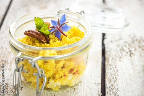 Delicious couscous with nuts and curry on wooden background