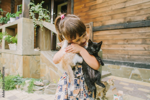 girl playing with kittens on a bench