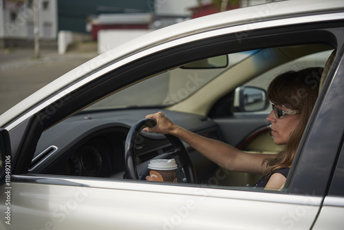 Girl with coffee while driving car © volodyar