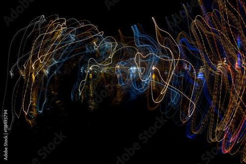 Abstract drawing by light with colored lines cyclic on a black