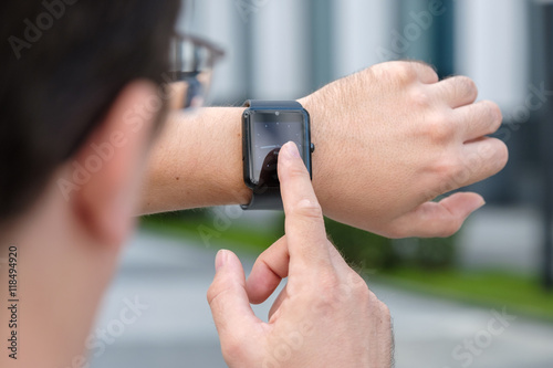 Man using smart watch outdoors