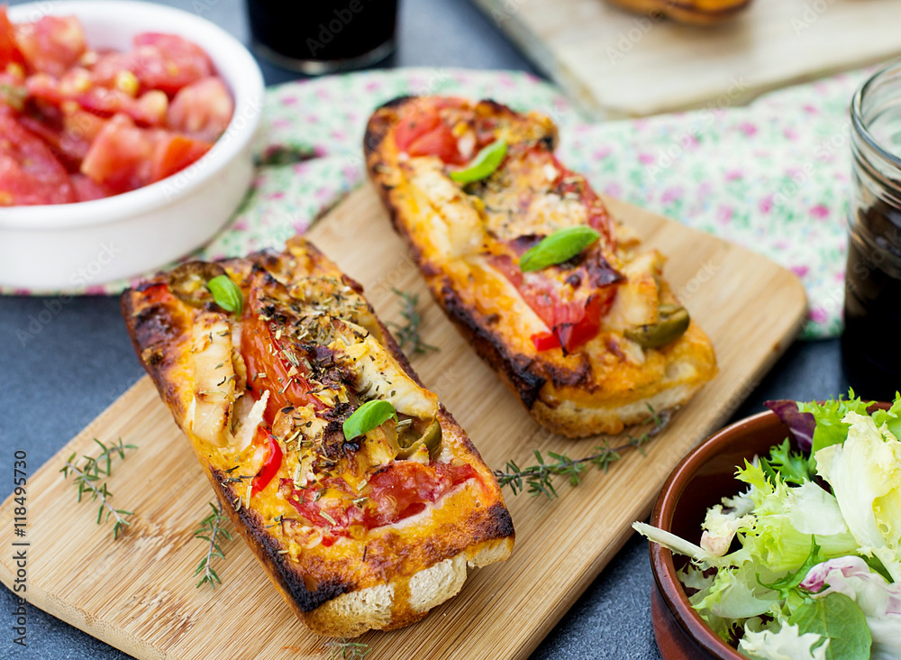 Grilled open faced sandwich with tomato, olives, cheese and chic
