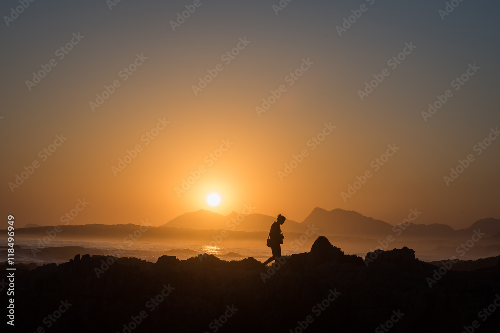 Persona osserva il tramonto sul mare