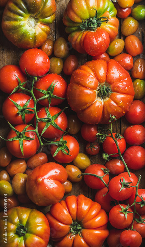 Colorful tomatoes of different sizes and kinds, top view, vertical