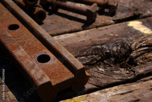 古い枕木の上の錆びた鉄骨と太いボルト