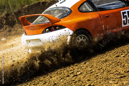 Autocross on a dusty road. Close-up of car in competition up road on a dirt road. Powerful auto throws dirt © kanzefar