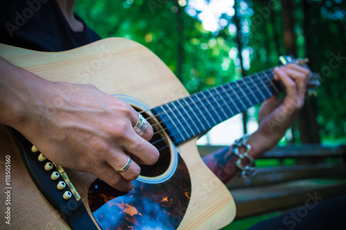 Man with tattoo playing classical guitar