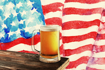 Glass of beer on wooden table. USA flag background.