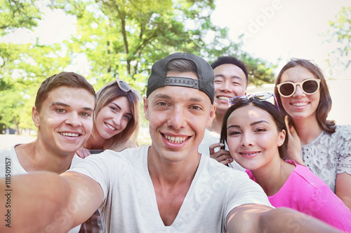 Group of happy teenagers taking selfie on street