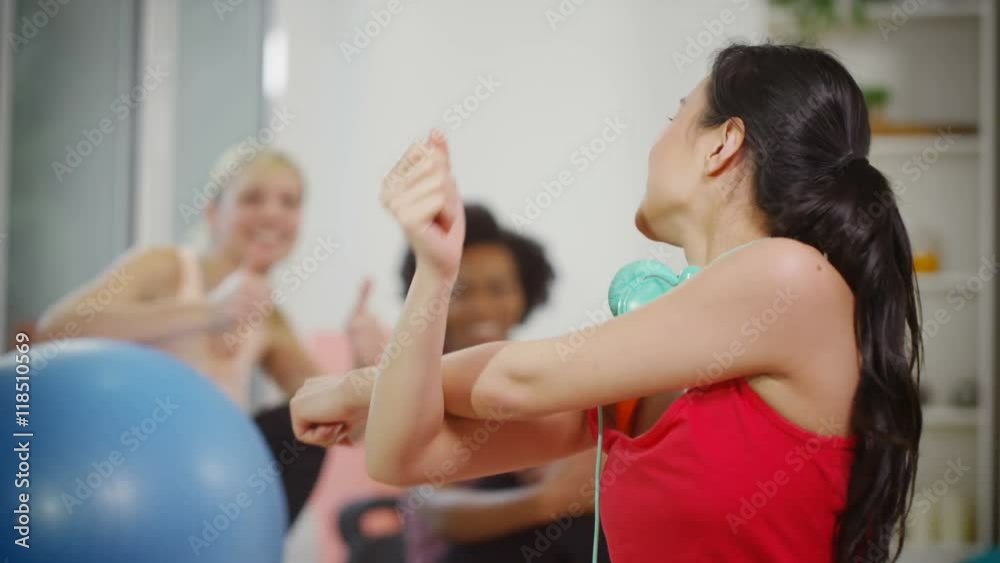 Portrait of smiling woman taking a break & talking to friends in exercise cla Portrait of smiling woman taking a break & talking to friends in exercise cla