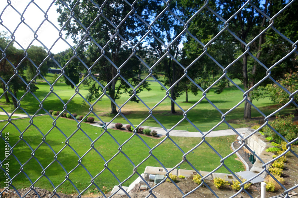 Chan Link fence with golf course in background Chan Link fence with golf course in background