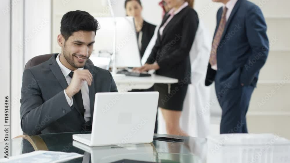Portrait smiling Arab businessman with business team in background Portrait smiling Arab businessman with business team in background