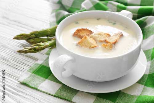 Asparagus soup with crackers on table