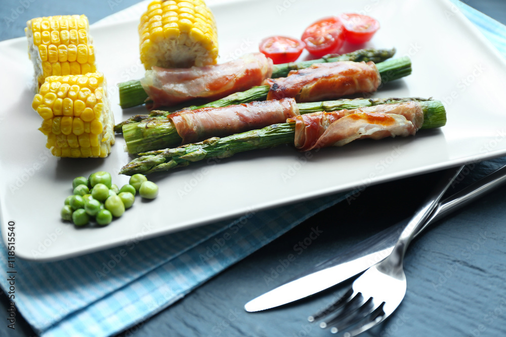 Asparagus with bacon and vegetables on plate