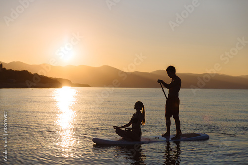 Silhouette of perfect couple engage standup paddle boarding