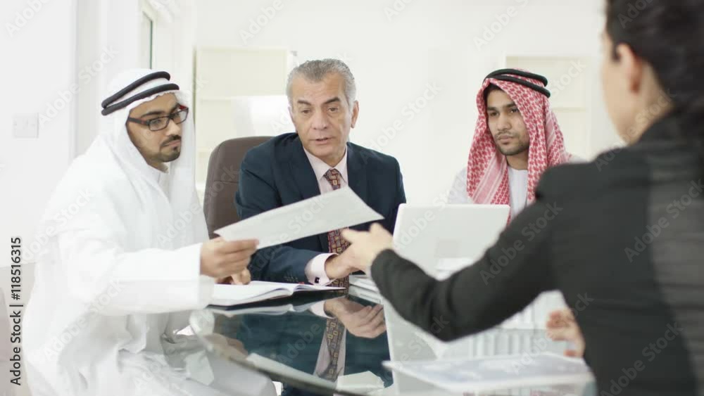 Smiling Arabic & Western business group in meeting shake hands on a deal Smiling Arabic & Western business group in meeting shake hands on a deal