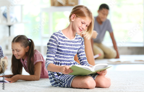 Cute girl reading book at home