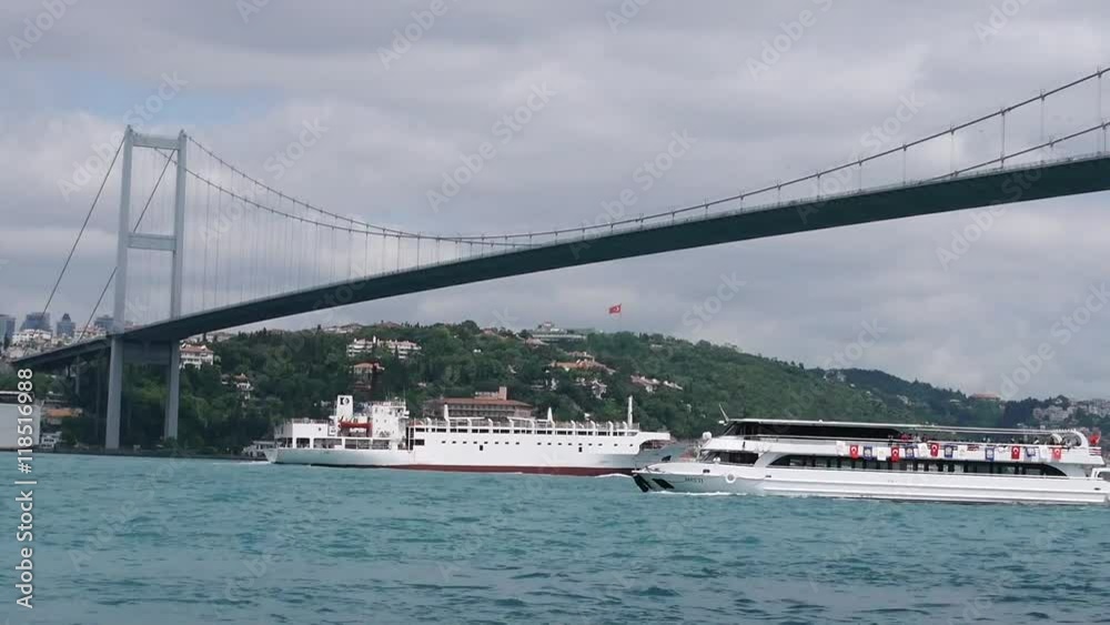 Passenger boat and cargo ship sails under the bridge Ataturk. Bosphorus. Istanbul. Turkey. Passenger boat and cargo ship sails under the bridge Ataturk. Bosphorus. Istanbul. Turkey.