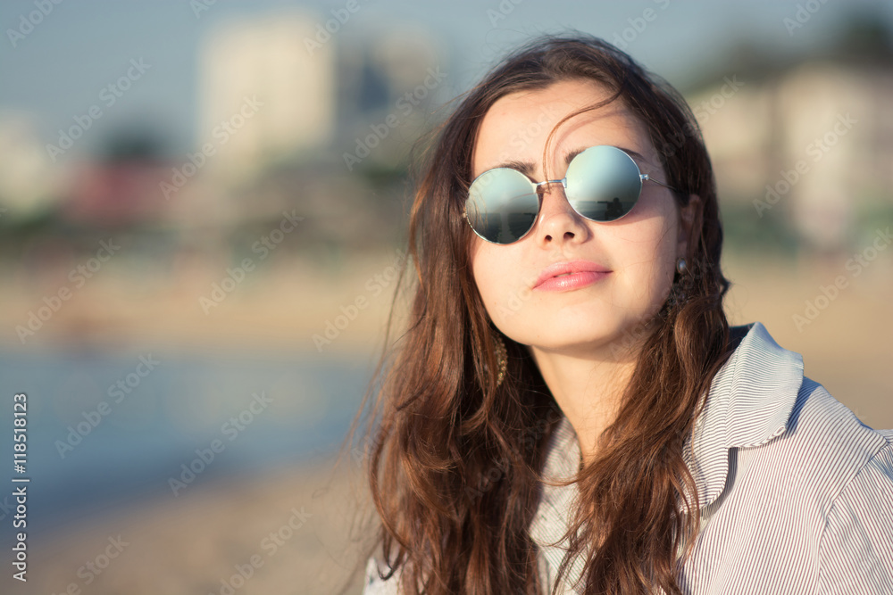 portrait of beautiful young woman with glasses near the sea