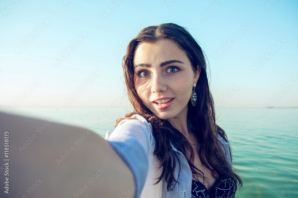 selfie woman in wet shirt at sea beach