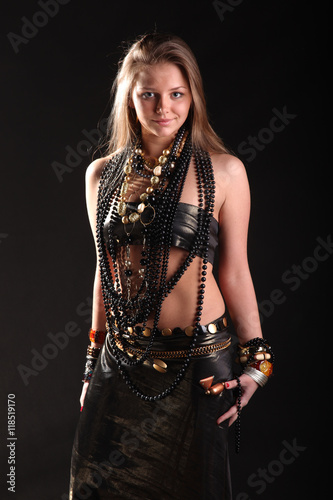 young girl in beads and bracelets on black background