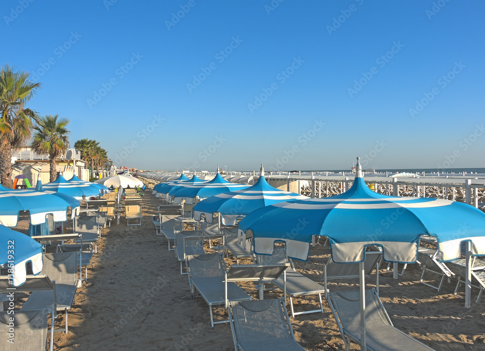 Umbrellas and gazebos on Italian sandy beaches. Adriatic coast. Pictures taken at sunrise          
