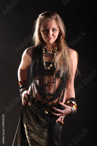young girl in beads and bracelets on black background