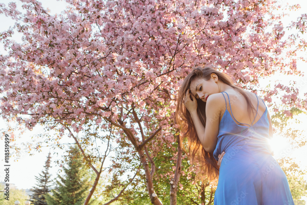 Beautiful young woman standing near the apple tree. Beautiful young woman standing near the apple tree.