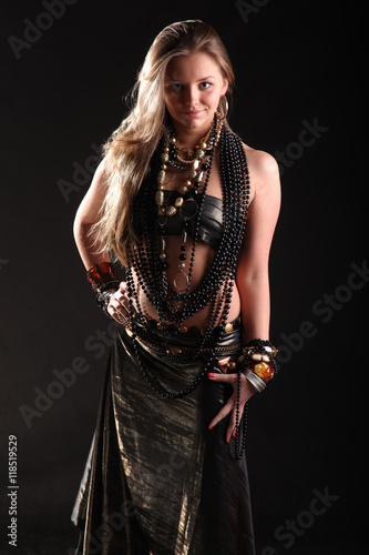 young girl in beads and bracelets on black background