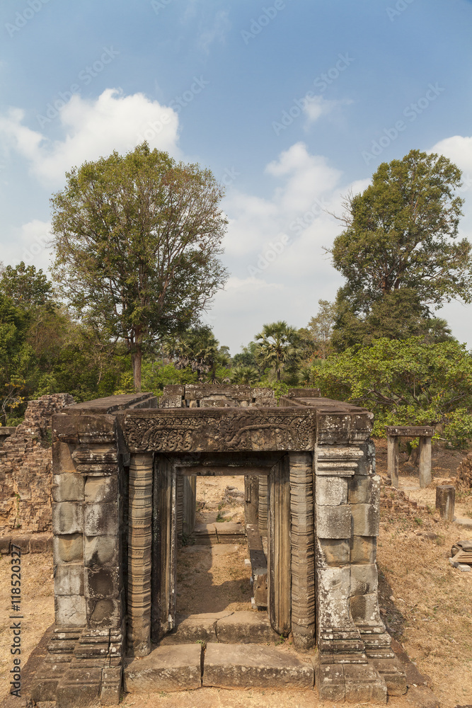 Gate in a Pre Rup temple, Angkor, Cambodia. Tropical trees in a background