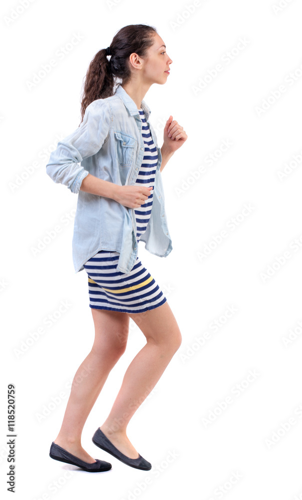 side view of running woman. beautiful girl in motion. backside view of person. Rear view people collection. Isolated over white background. Swarthy girl in a checkered dress runs in the side side view of running woman. beautiful girl in motion. backside view of person. Rear view people collection. Isolated over white background. Swarthy girl in a checkered dress runs in the side
