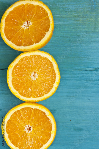 Photo of bright oranges, cut in halves, on blue background