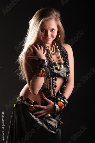 young girl in beads and bracelets on black background