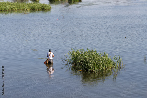 Fisherman catches a fish in the Volga peals. Catching carp and bass in the stream. Healthy lifestyle.