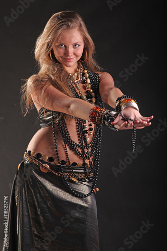 young girl in beads and bracelets on black background