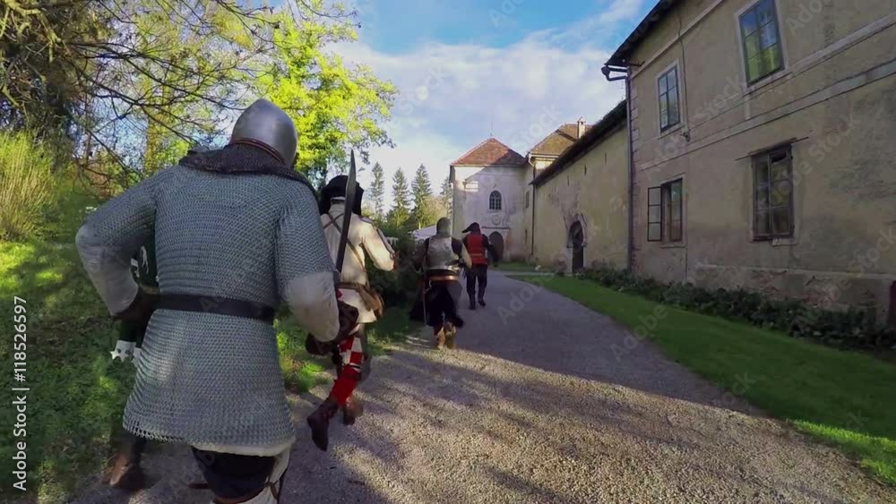 Knights are following another knight. They are running after him and are having swords in their hands. They stop at the castle's entrance. Wide-angle shot.
Knights are following another knight. They are running after him and are having swords in their hands. They stop at the castle's entrance. Wide-angle shot.