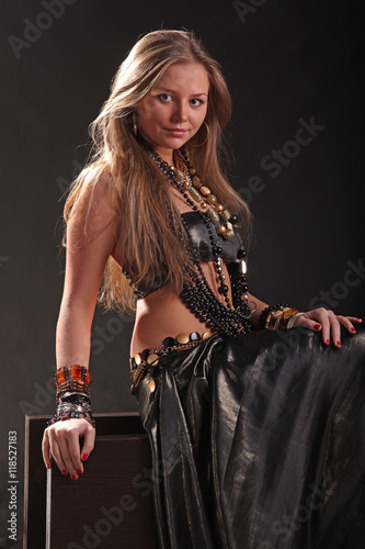 young girl in beads and bracelets on black background