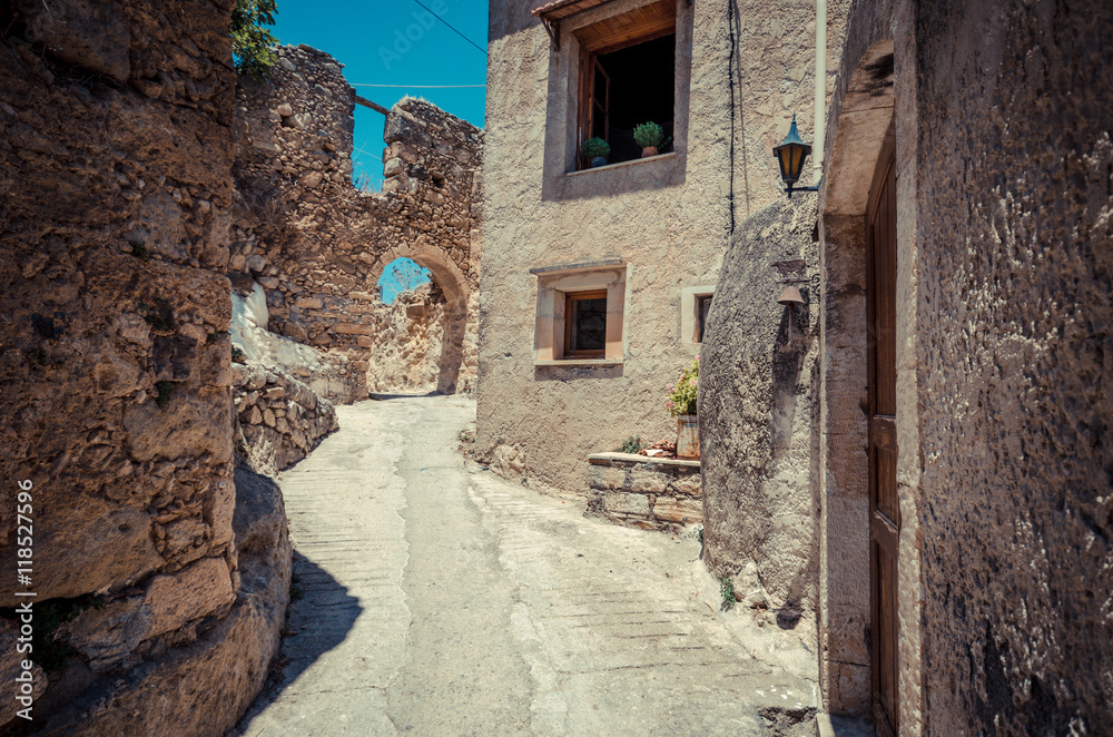 Old narrow street with stone arch at Maroulas, Crete 