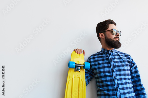 Valokuva bearded hipster in checkered shirt holding yellow skateboard