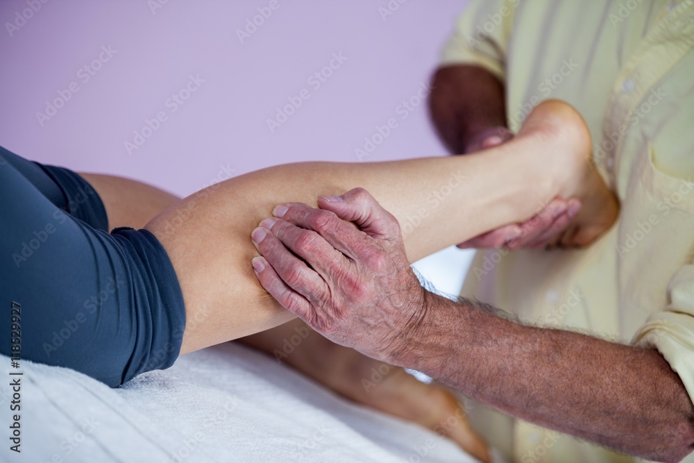 Fototapeta premium Physiotherapist giving leg massage to a woman