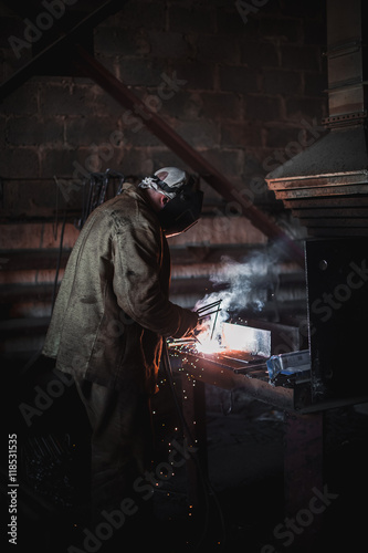 job of a welder. A large concrete products plant and welding on it.