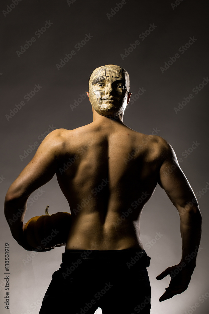 Fototapeta premium muscular man in mask with pumpkin