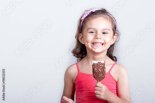 Young girl feeling happy while eating chocolate ice cream bar